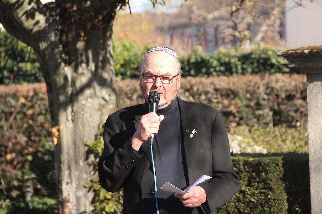 Mann spricht an Gedenkstaette
